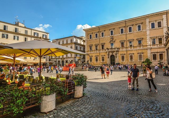 Italian restaurant terrace in a historic city square with outdoor seating and pedestrians